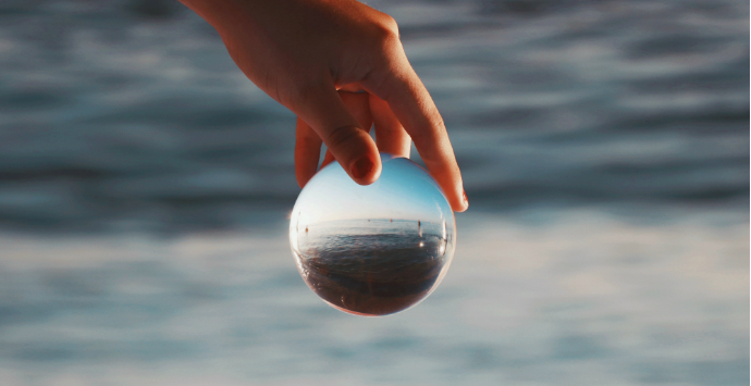 Photographie d'une main avec une boule transparente