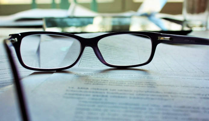 Photographie d'une paire de lunettes sur un cahier ouvert