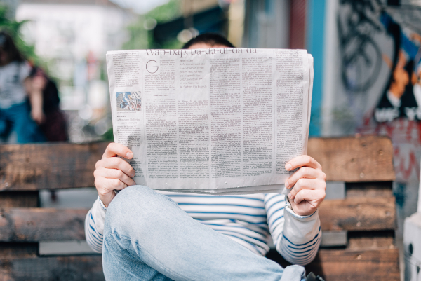 Photographie d'une personne lisant un journal