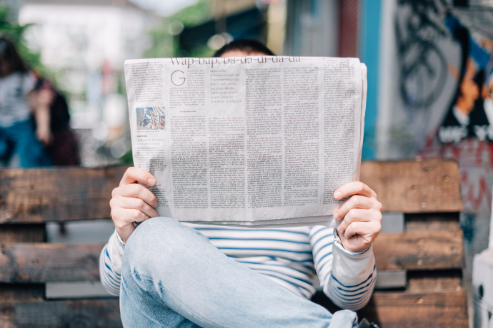 Photographie d'un homme lisant un journal