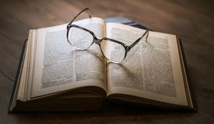 Photographie d'un livre avec des lunettes posées dessus