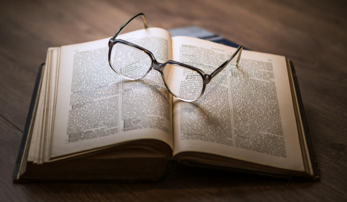 Photographie d'un livre avec des lunettes posées dessus